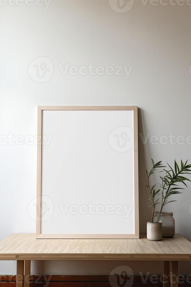 Mock up of a blank frame on a wooden table with a plant in front of it photo