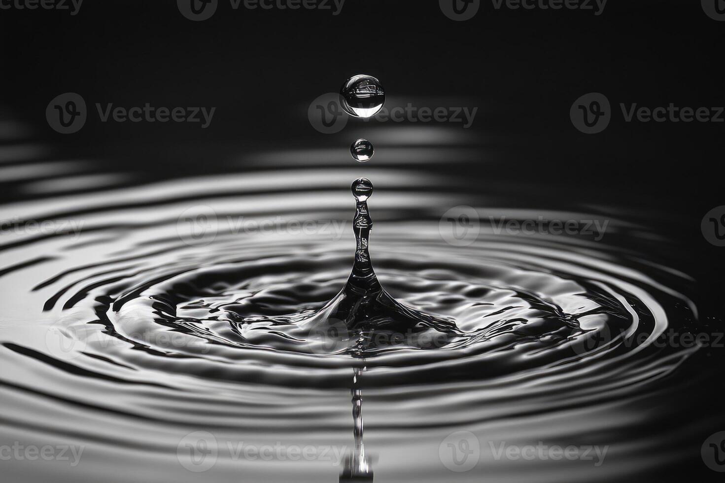 Water droplet falling creating concentric ripples on water surface photo