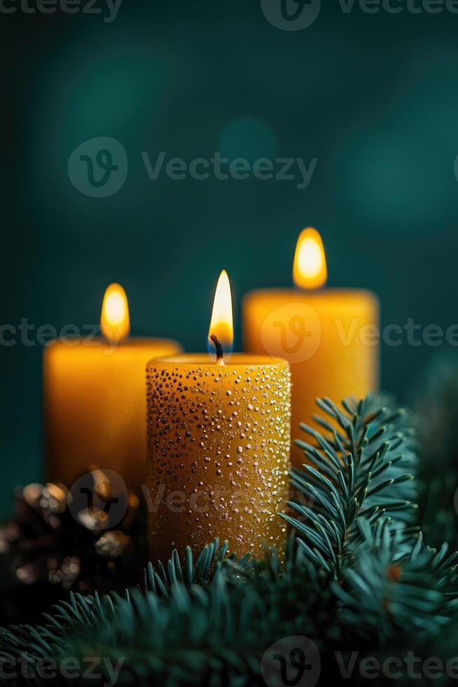 Burning advent candles with evergreen branches and pine cones on green background photo