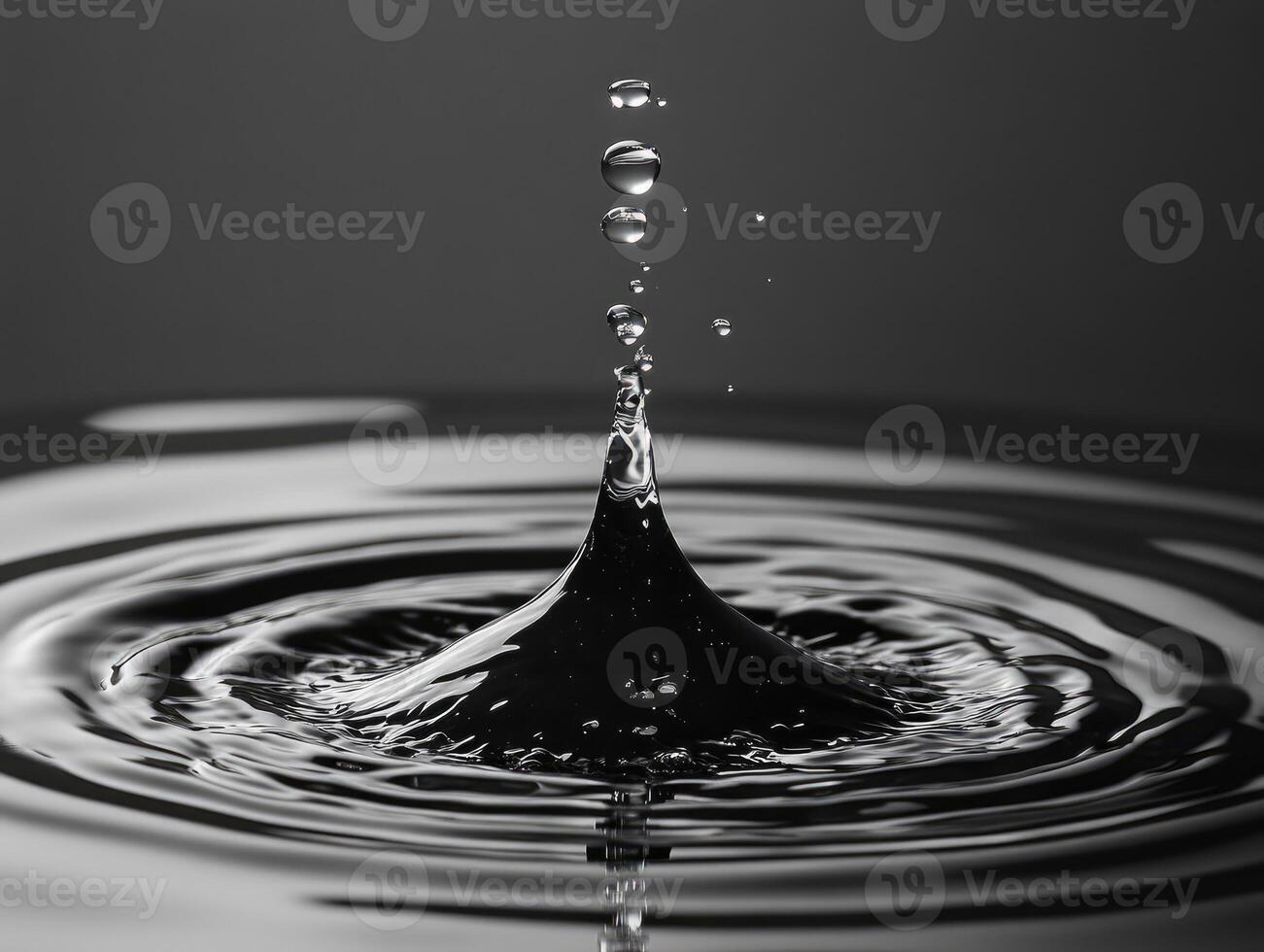 Water droplet falling creating concentric ripples on water surface photo