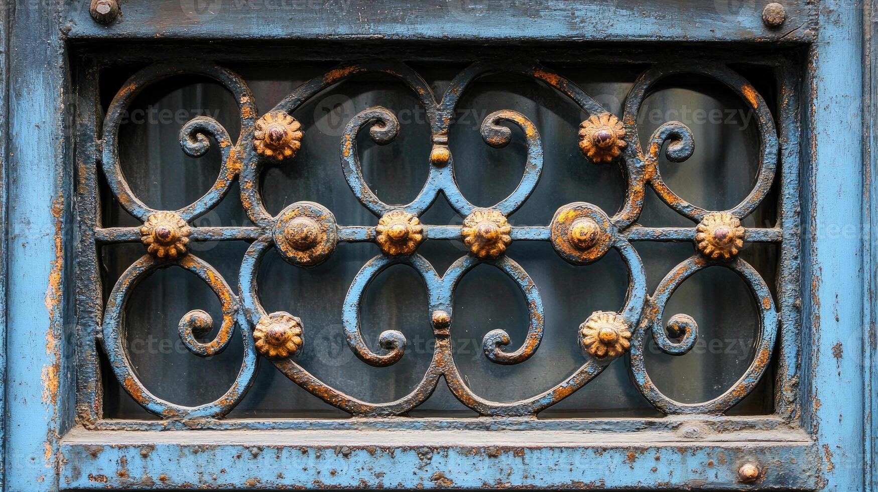 Old ornate rusty metal grate protecting window showing through photo