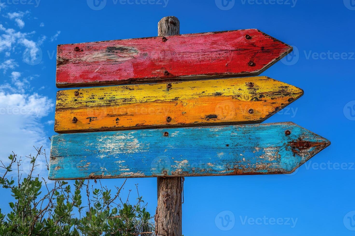 Three colorful wooden arrows pointing in different directions on a signpost photo