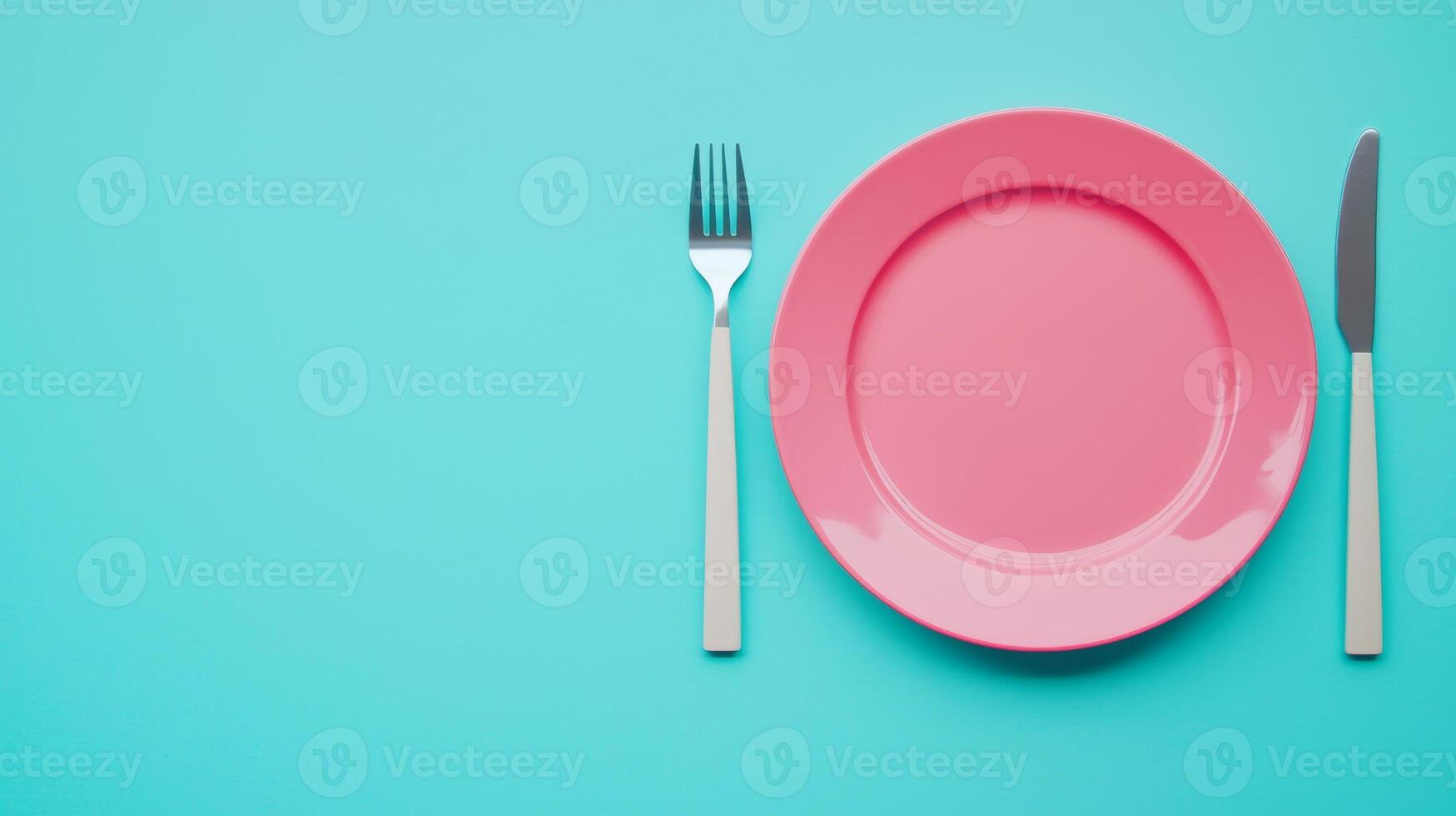 Elegant Dinner Setting with Pink Plate, Fork, and Knife on a Vibrant Turquoise Background photo
