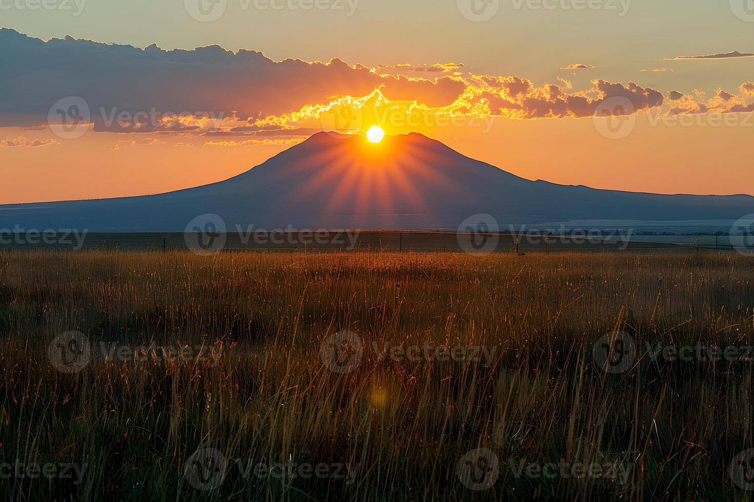Majestic Sunset Over Mountain Landscape with Golden Grassy Field photo