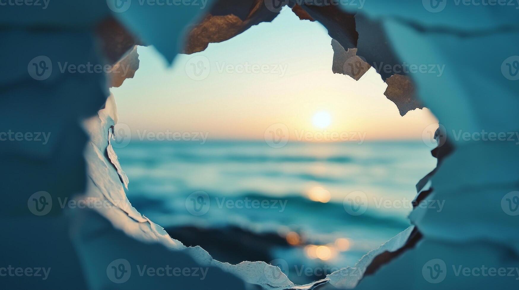 torn paper creates a unique frame offering a glimpse of a mesmerizing sunset on the horizon highlighting the blend of creativity and natural splendor. photo