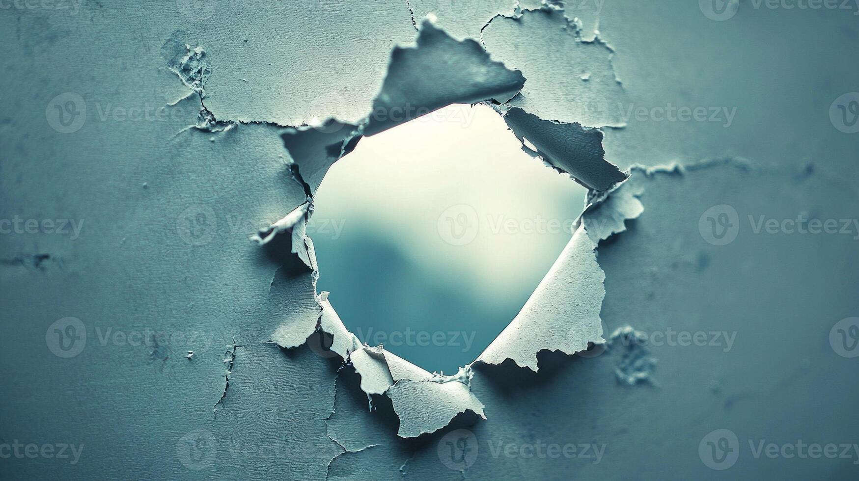 striking torn paper hole reveals a soft blurred image beneath surrounded by a dynamic backdrop. This artistic composition draws the viewers eye inviting curiosity about the hidden world. photo