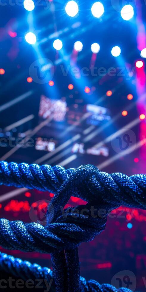 vibrant lights highlight a wrestling ring equipped with three ropes setting the stage for an electrifying performance where athletes showcase their skills. photo