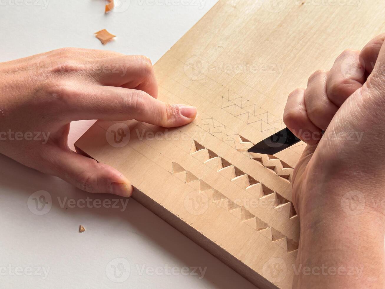Hand carving intricate geometric patterns on wood with precision and skill photo