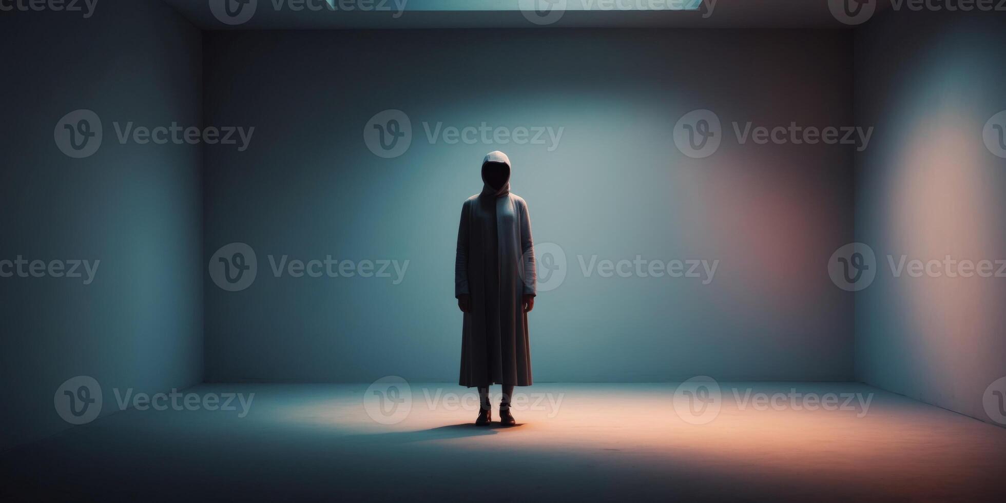 A man standing in an empty room with a light coming from the ceiling photo