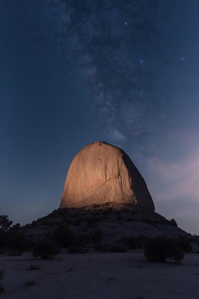 The milky way over the rock formation in the desert photo