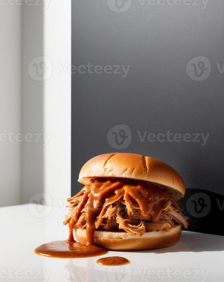 A pulled pork sandwich with sauce on a white table photo