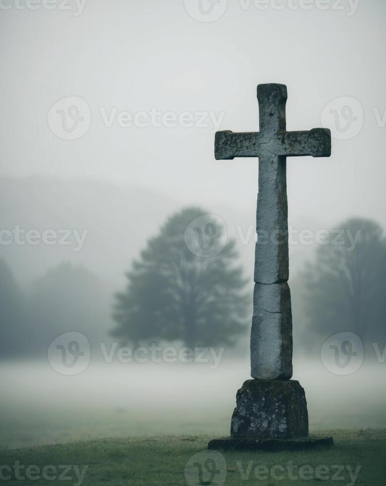 Misty Landscape with Weathered Cross in the Foreground. photo