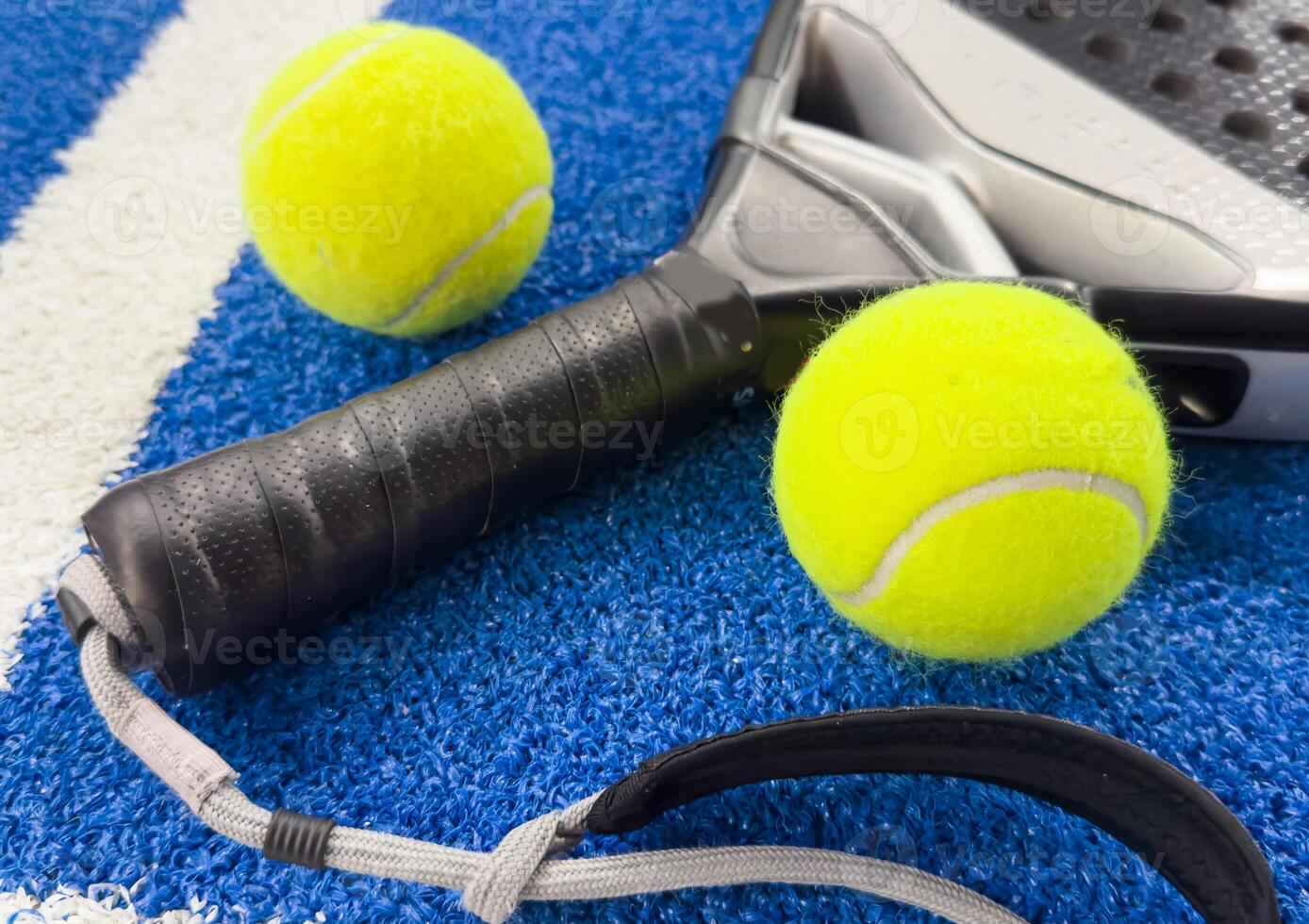Paddle racket with a ball ready to play the fastest growing sport in recent years worldwide. Padel court in summer, the perfect time to practice this sporting discipline and release stress. photo