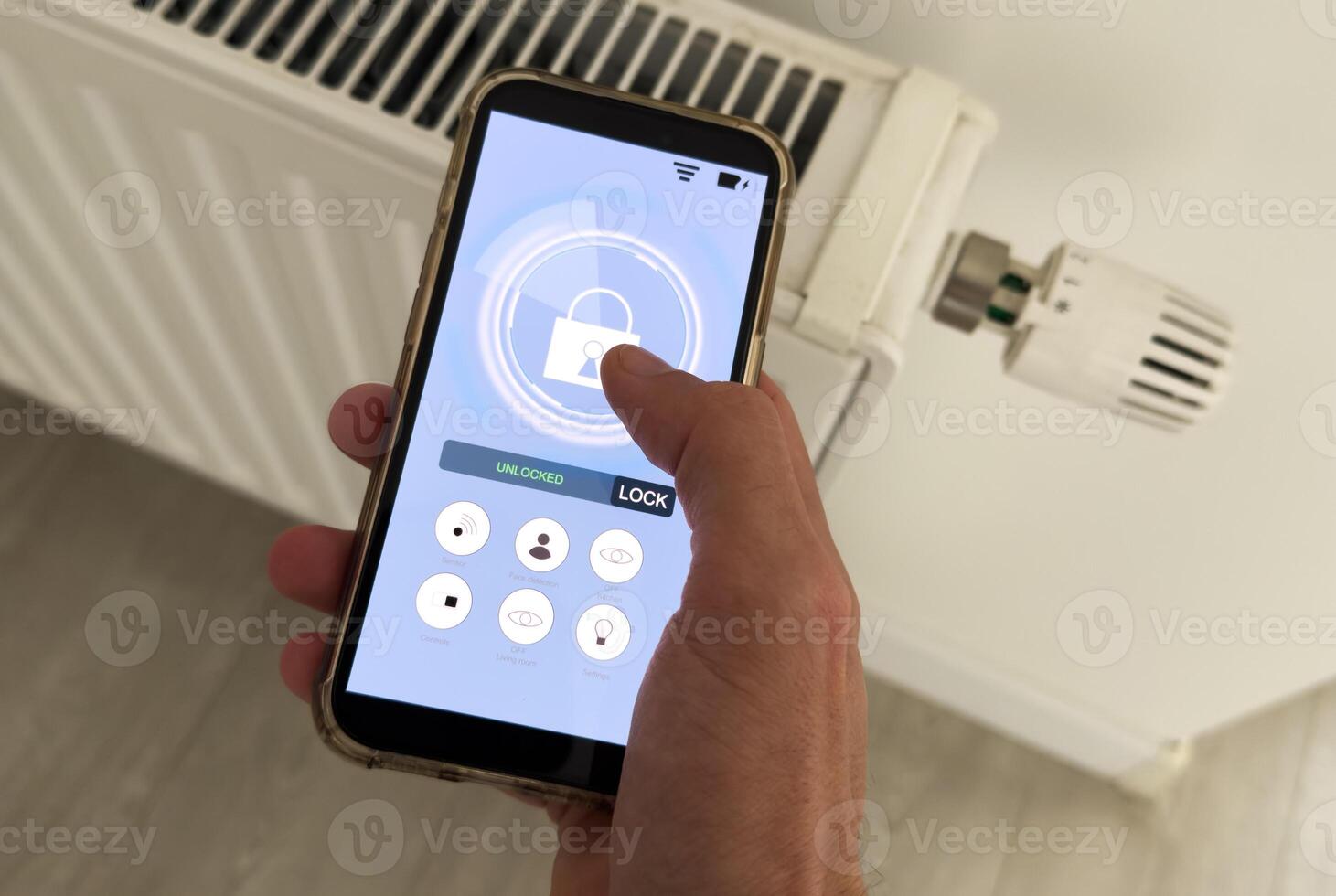 Controlling radiator heating temperature with a smart phone, close-up with radiator on the background. Concept of a smart home and mobile application for managing smart devices at home photo
