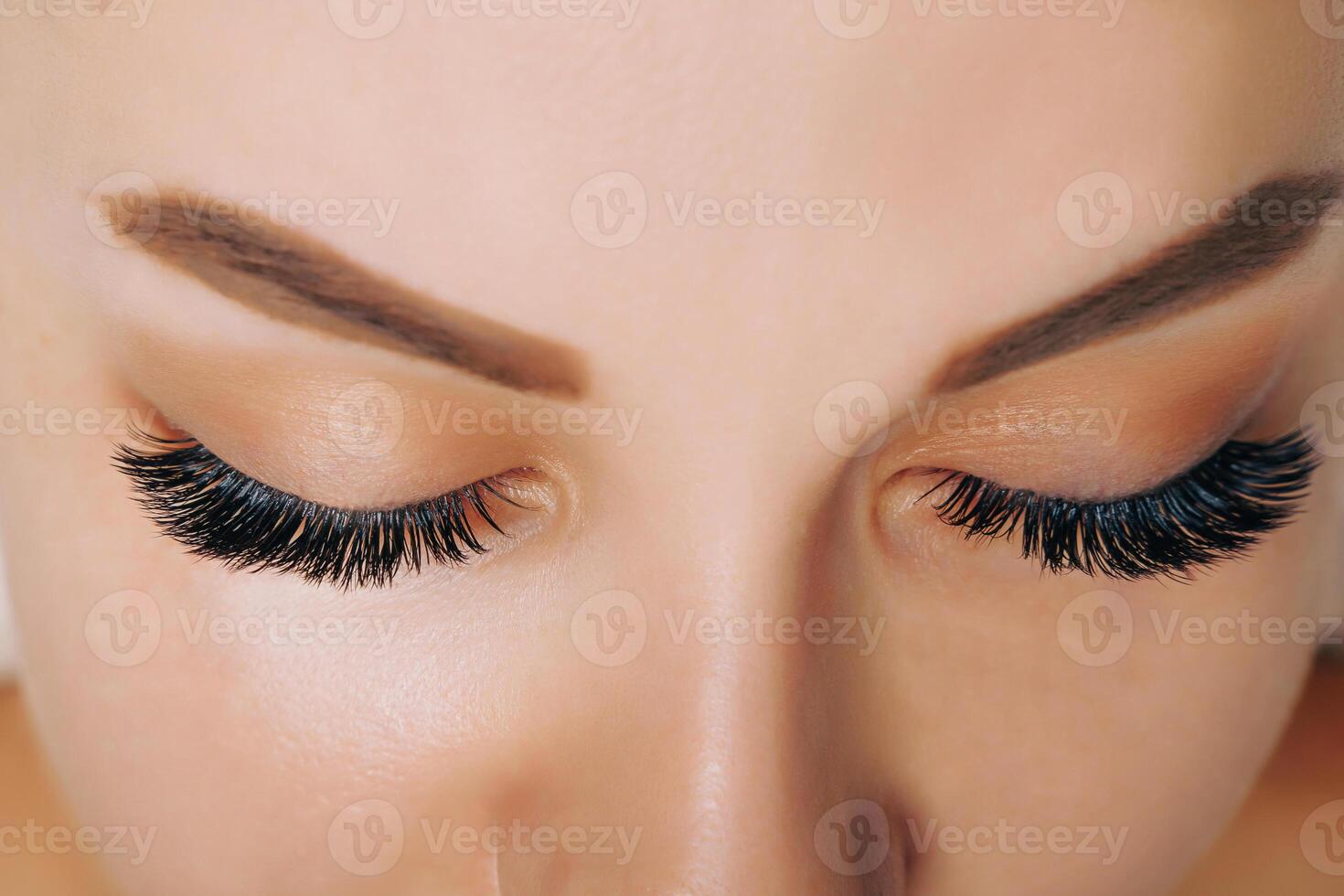 Eyelash Extension Procedure. Woman Eye with Long Eyelashes. Close up, selective focus. photo