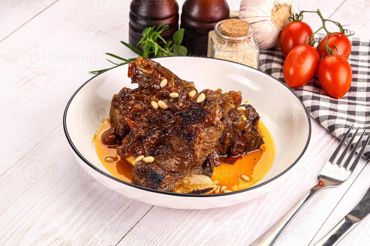 Prepared tasty beef ribs with sauce photo