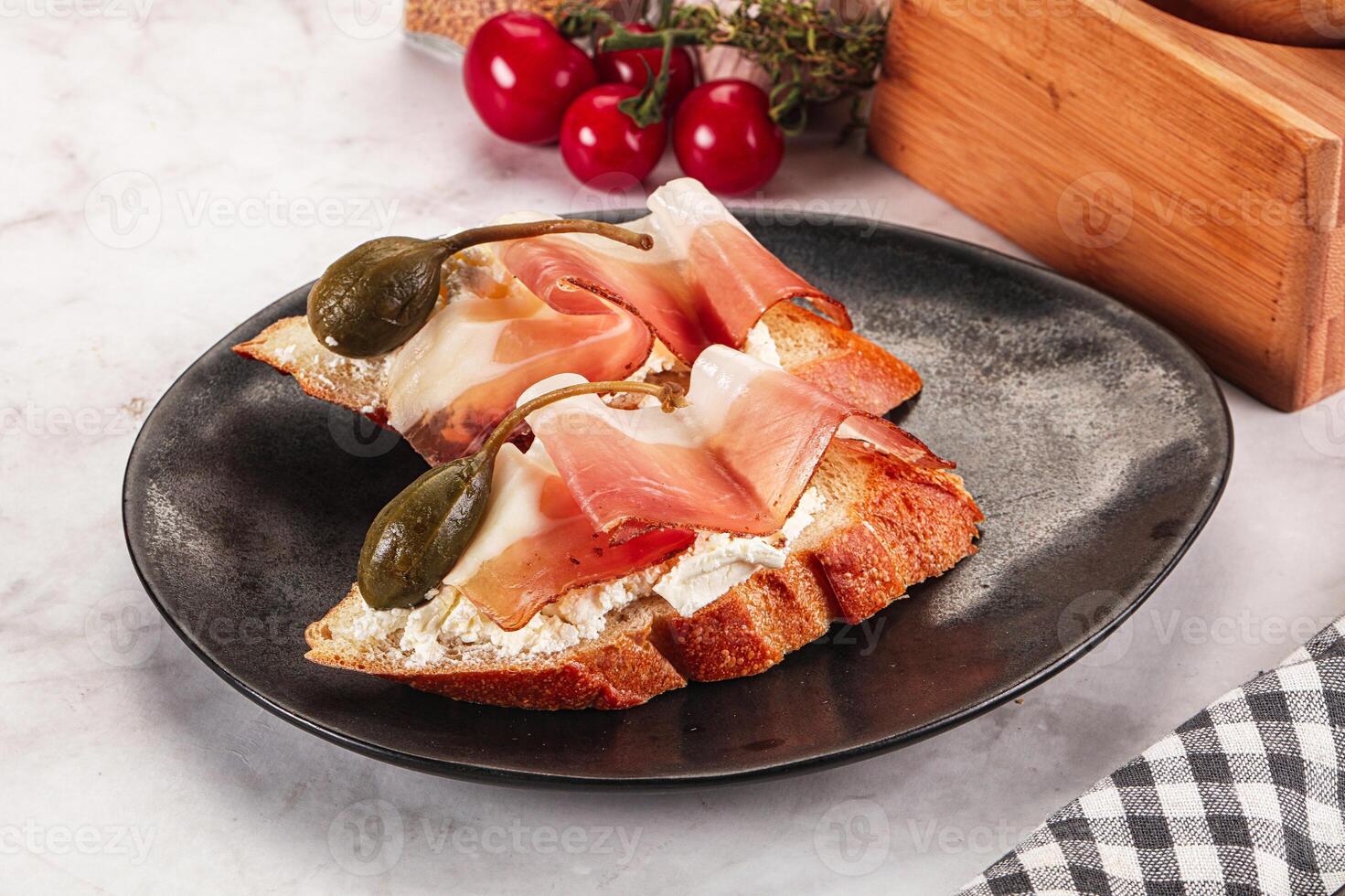 Bruschetta with jamon and caper berries photo
