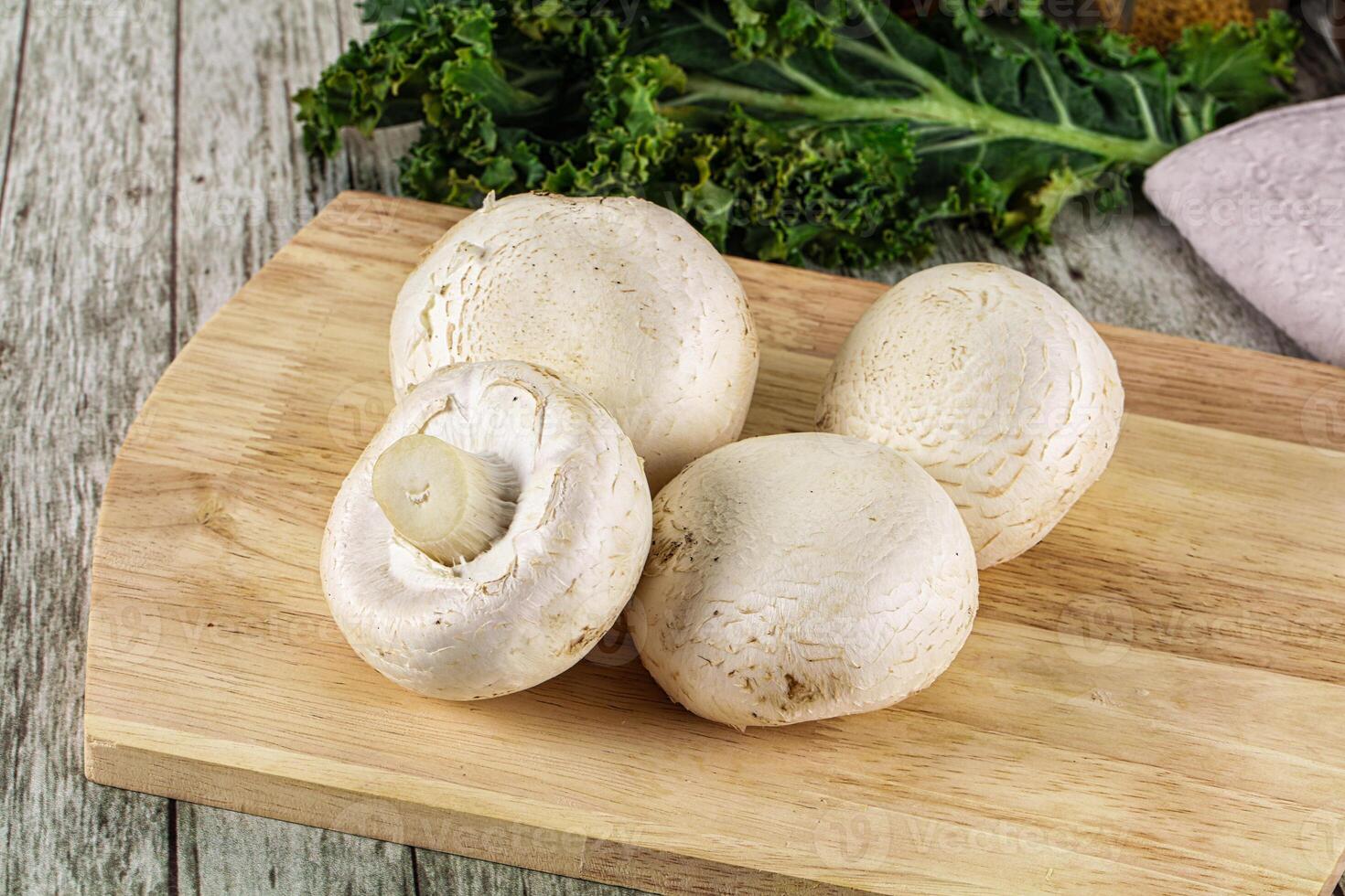 White champignon mushrooms heap over board photo