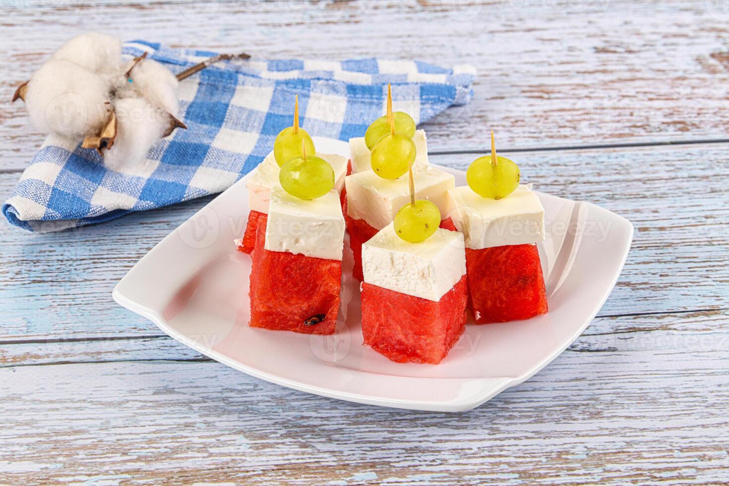 A plate with watermelon and cheese on sticks photo