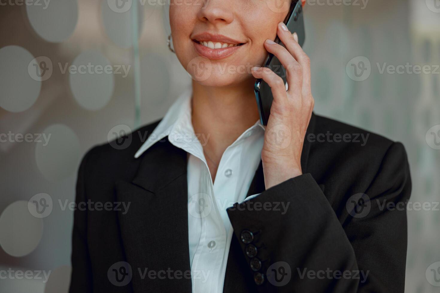 The professional businesswoman in an elegant suit is having a phone conversation photo