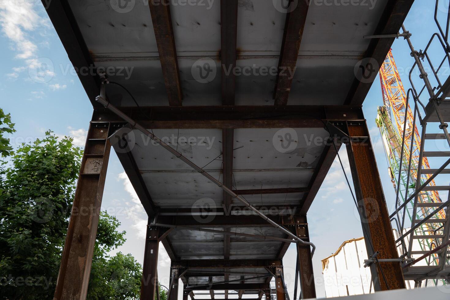 A minimalist urban scene showcasing a construction site with a towering crane. Highlights the intersection of infrastructure, development, and modern architecture under a clear sky. photo