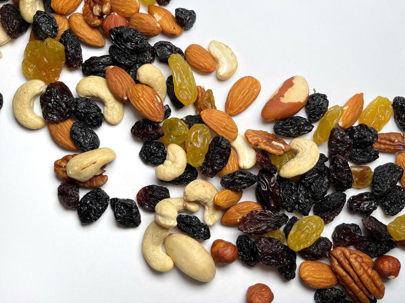Mixed Nuts Almonds, Walnuts, Cashews, Hazelnuts, Dried Prunes and Raisins. Different Nut Mix. Various Nuts and Dried Fruits on white background. photo