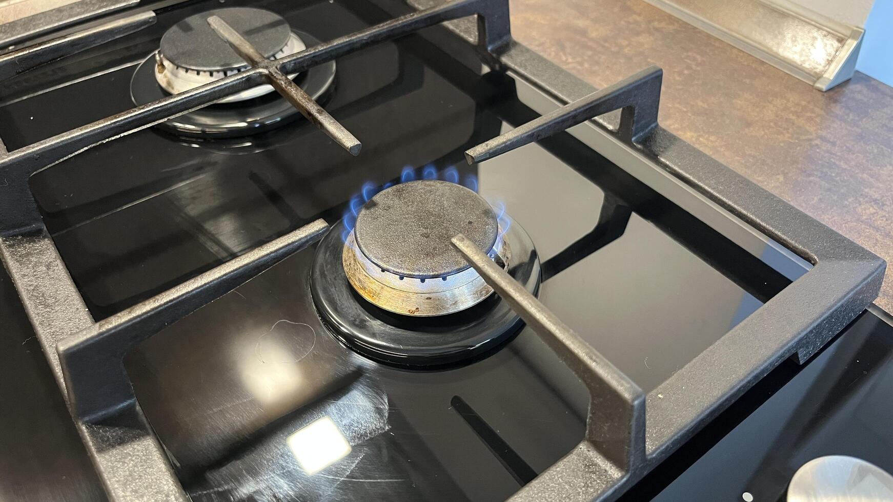 Gas stove with blue flame. Gas burner on a gas stove in the kitchen, close-up photo