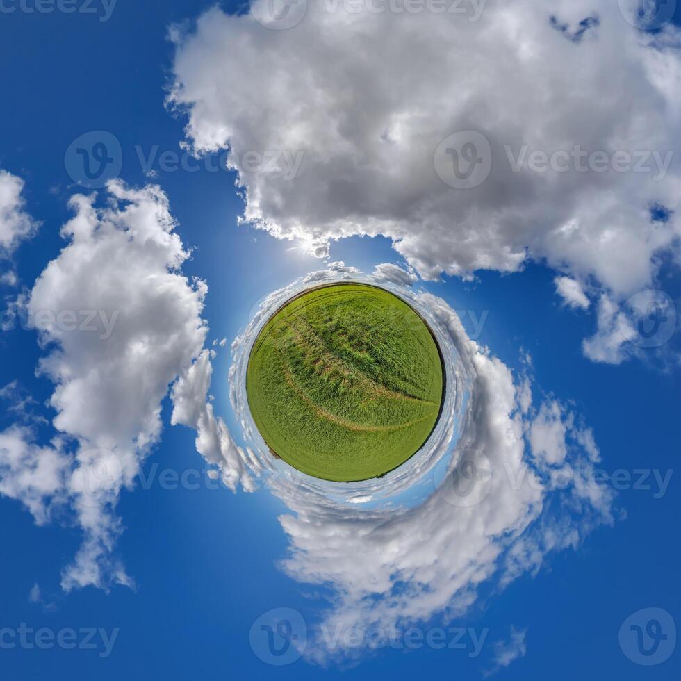 simple little tiny planet without buildings in blue sky with sun and beautiful clouds. Transformation of spherical panorama 360 degrees. Spherical abstract aerial view. Curvature of space. photo