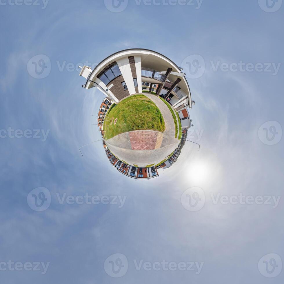 modern low-rise residential townhouse on surface of little tiny planet in blue sky with sun. Transformation of spherical panorama 360 degrees. Spherical abstract aerial view. Curvature of space. photo