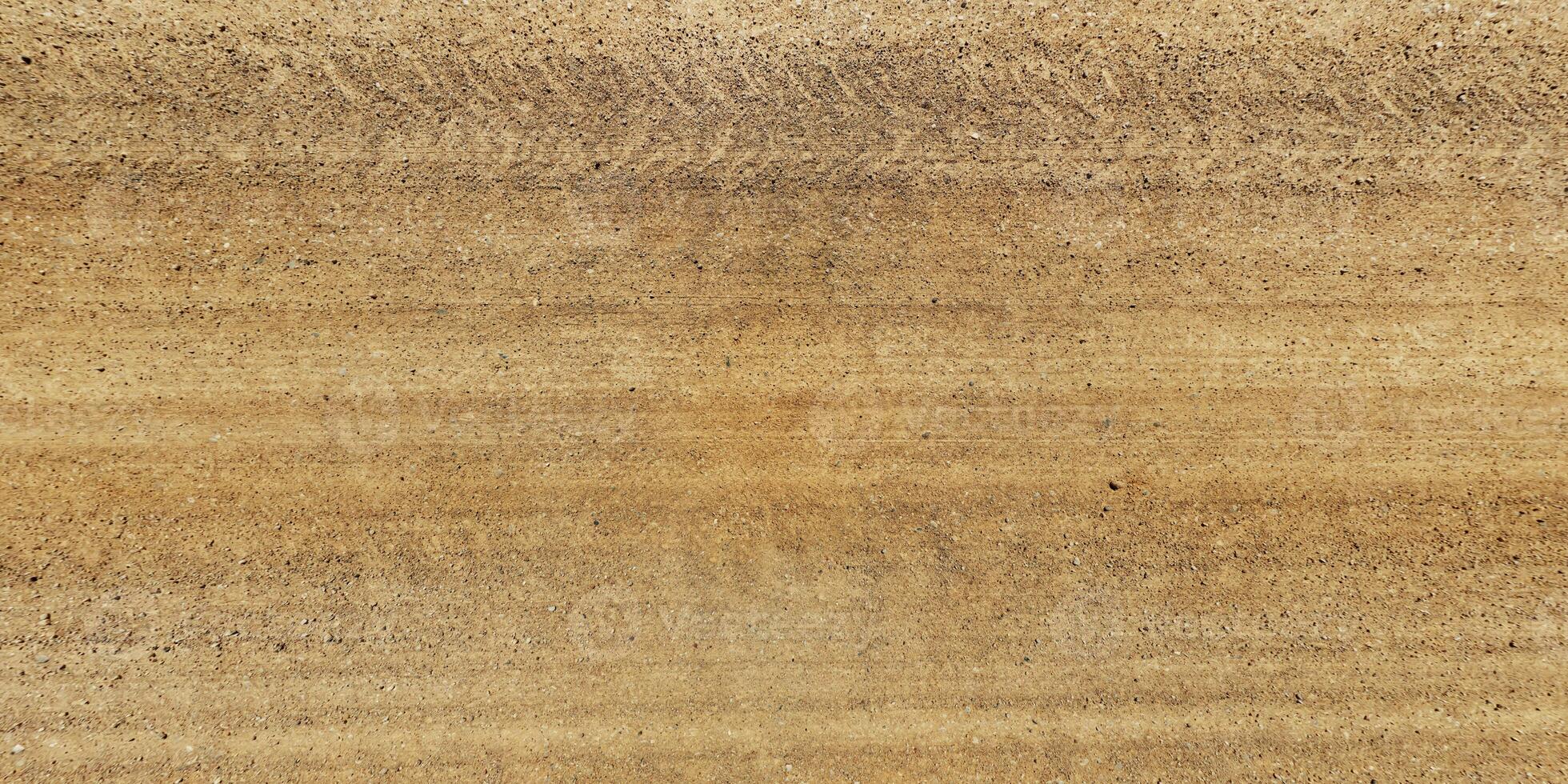 panorama view from above on texture of gravel sand road with car tire tracks photo