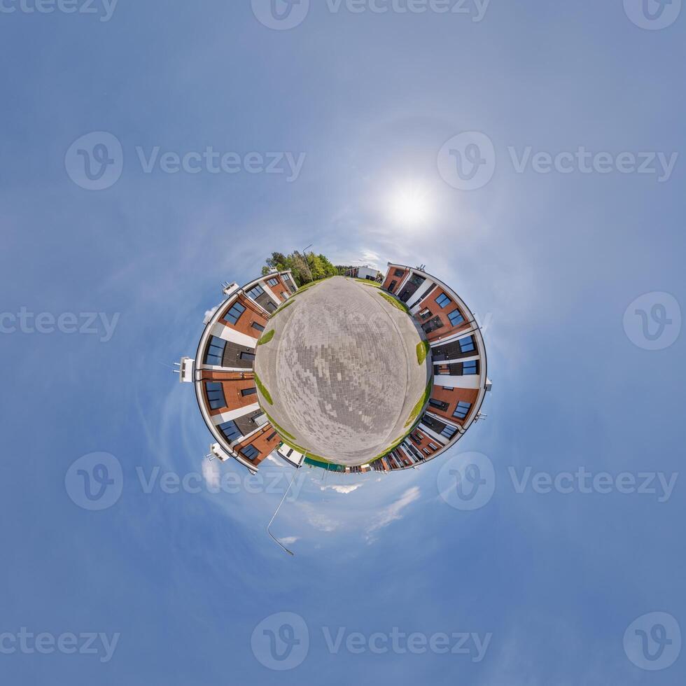 modern low-rise residential townhouse on surface of little tiny planet in blue sky with sun. Transformation of spherical panorama 360 degrees. Spherical abstract aerial view. Curvature of space. photo