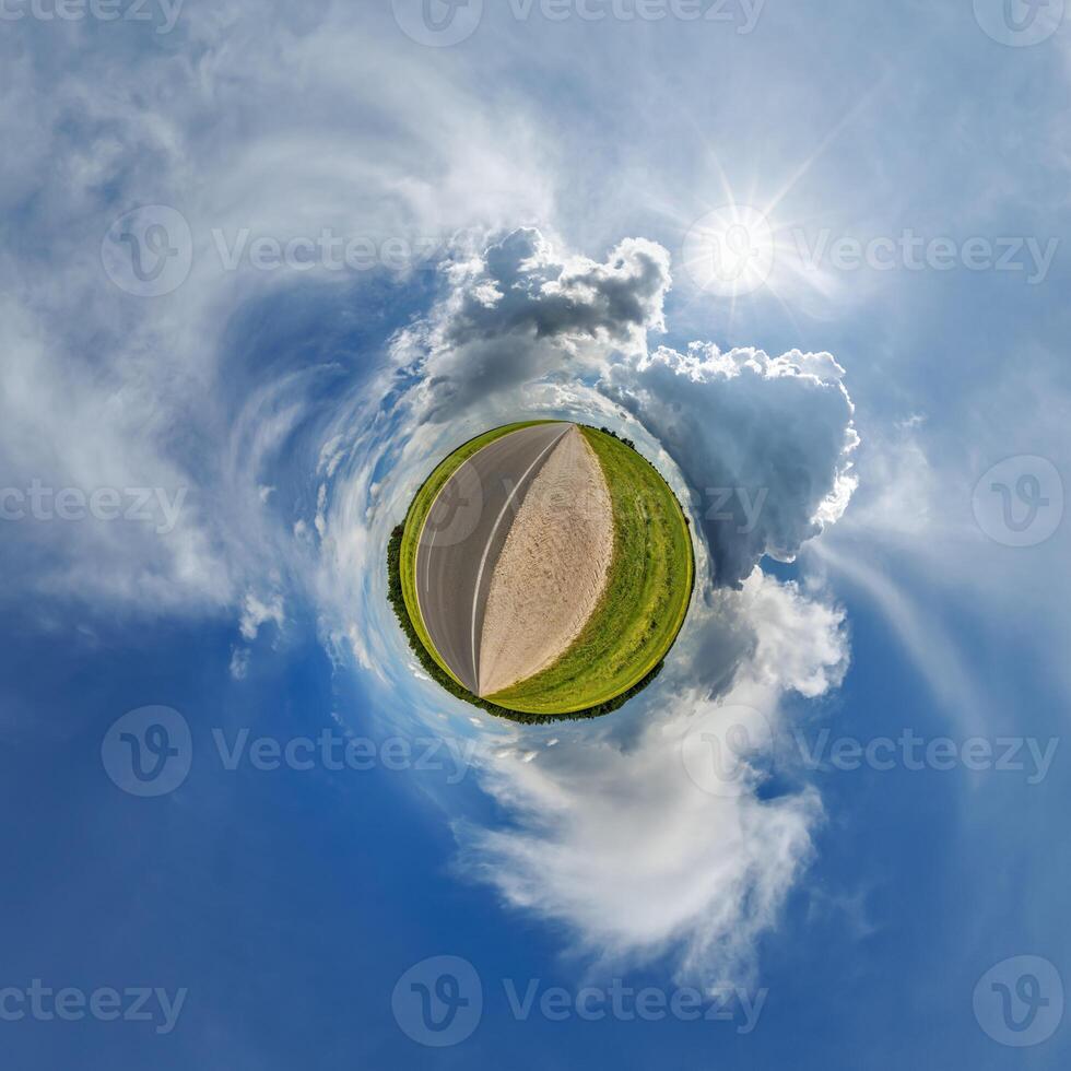 simple little tiny planet without buildings in blue sky with sun and beautiful clouds. Transformation of spherical panorama 360 degrees. Spherical abstract aerial view. Curvature of space. photo