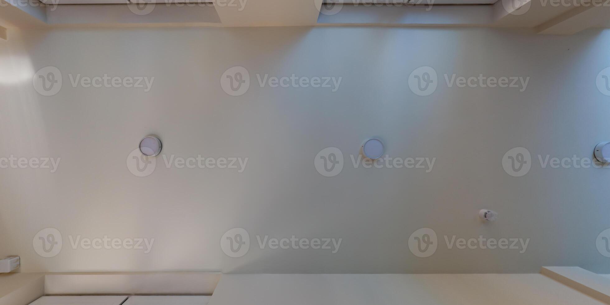 suspended ceiling with halogen spots lamps and drywall construction in empty room in apartment or house. Stretch ceiling white and complex shape. photo