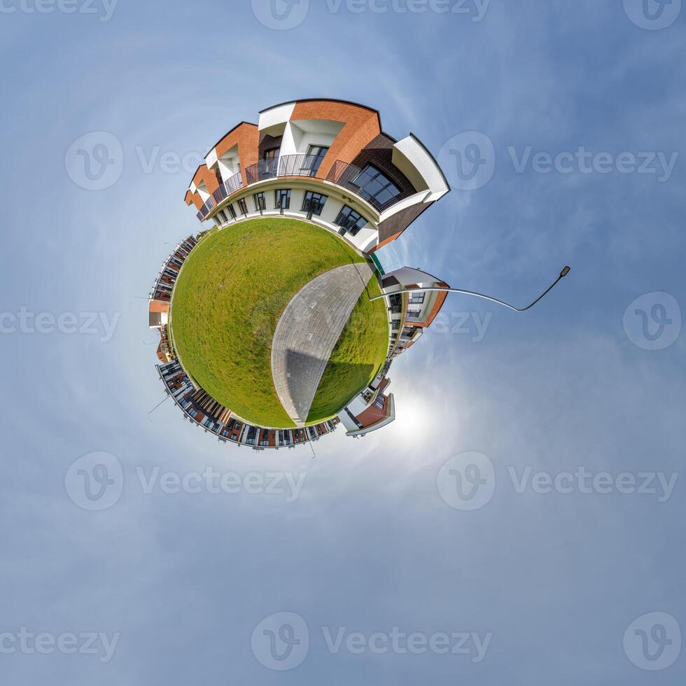 modern low-rise residential townhouse on surface of little tiny planet in blue sky with sun. Transformation of spherical panorama 360 degrees. Spherical abstract aerial view. Curvature of space. photo