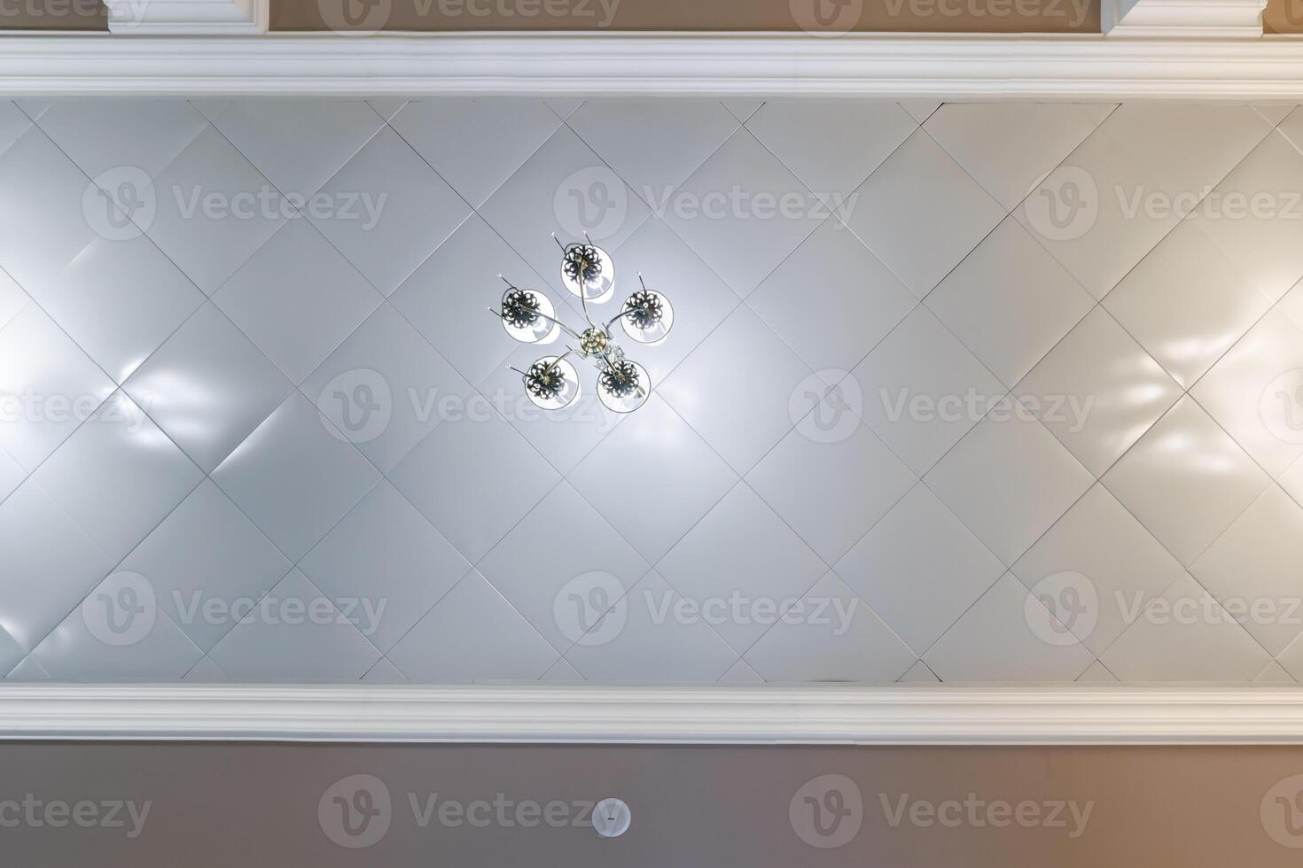 suspended ceiling with halogen spots lamps and drywall construction in empty room in apartment or house. Stretch ceiling white and complex shape. photo