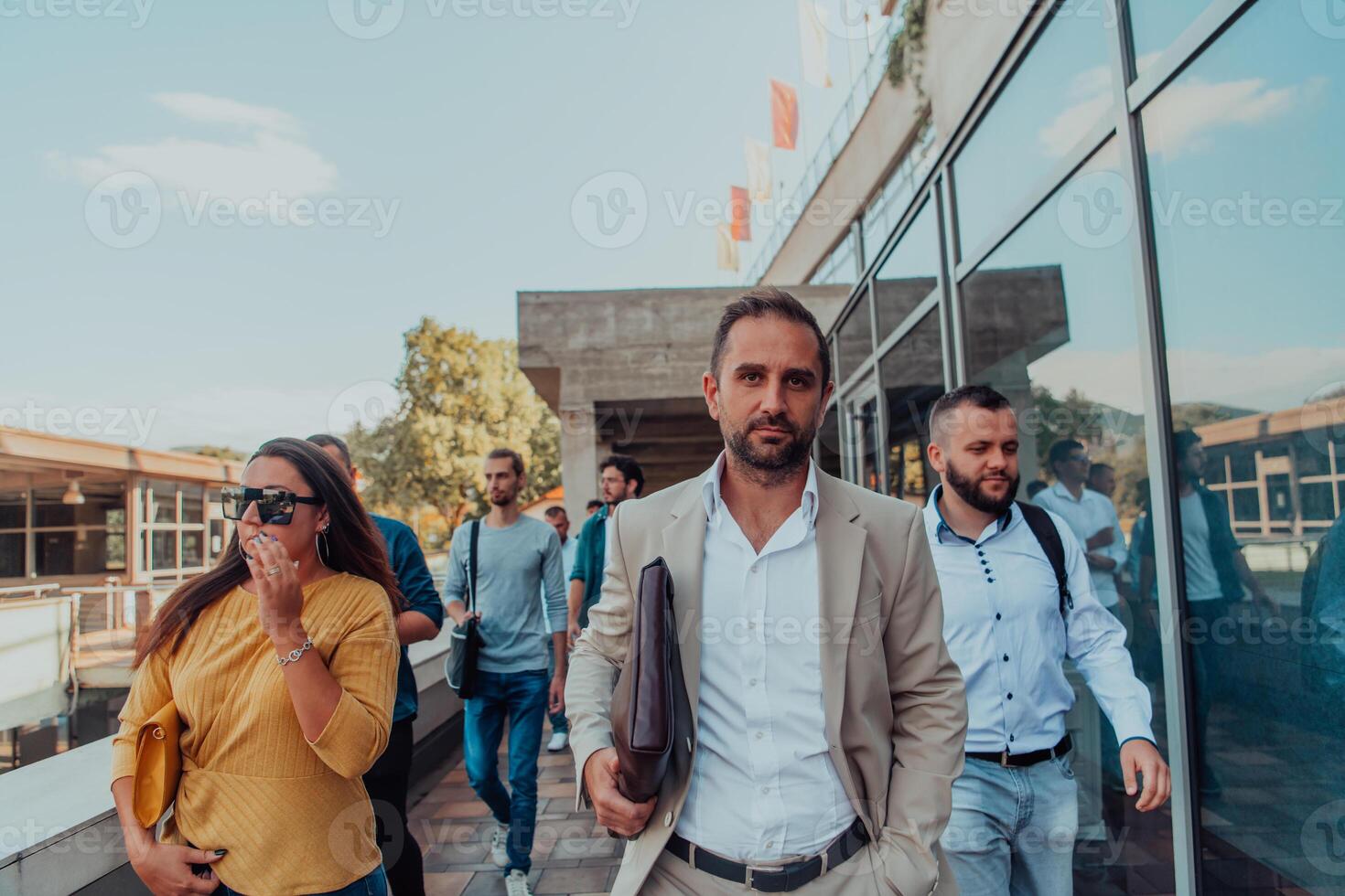 A diverse group of businessmen and colleagues walking together by their workplace, showcasing collaboration and teamwork in the company. photo