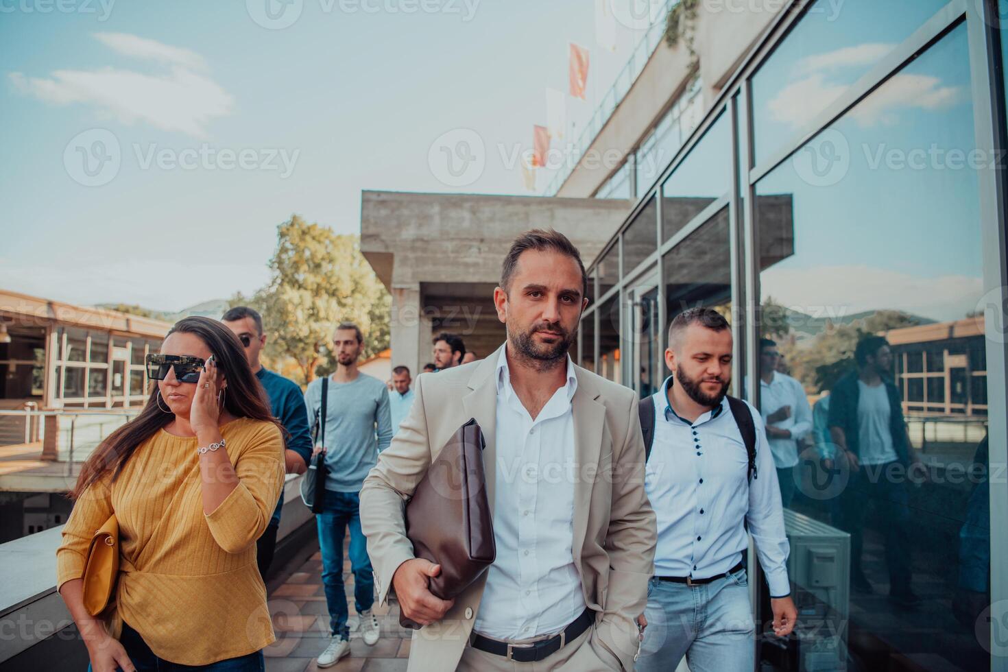 A diverse group of businessmen and colleagues walking together by their workplace, showcasing collaboration and teamwork in the company. photo