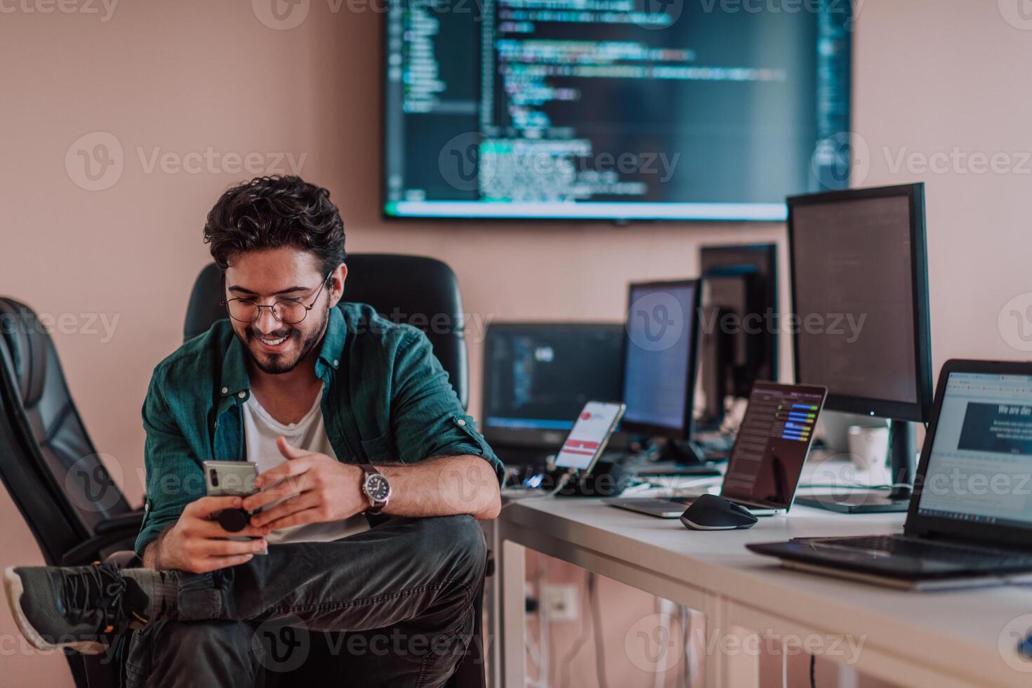 A programmer diligently testing smartphone applications while sitting in their office. photo