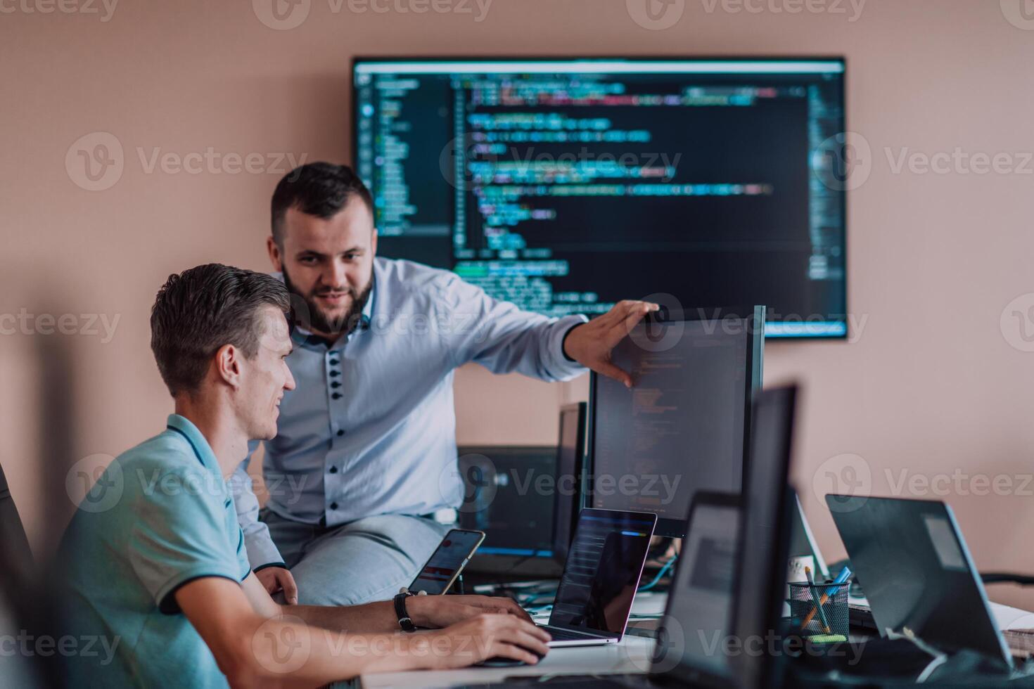 Programmers engrossed in deep collaboration, diligently working together to solve complex problems and develop innovative mobile applications with seamless functionality. photo