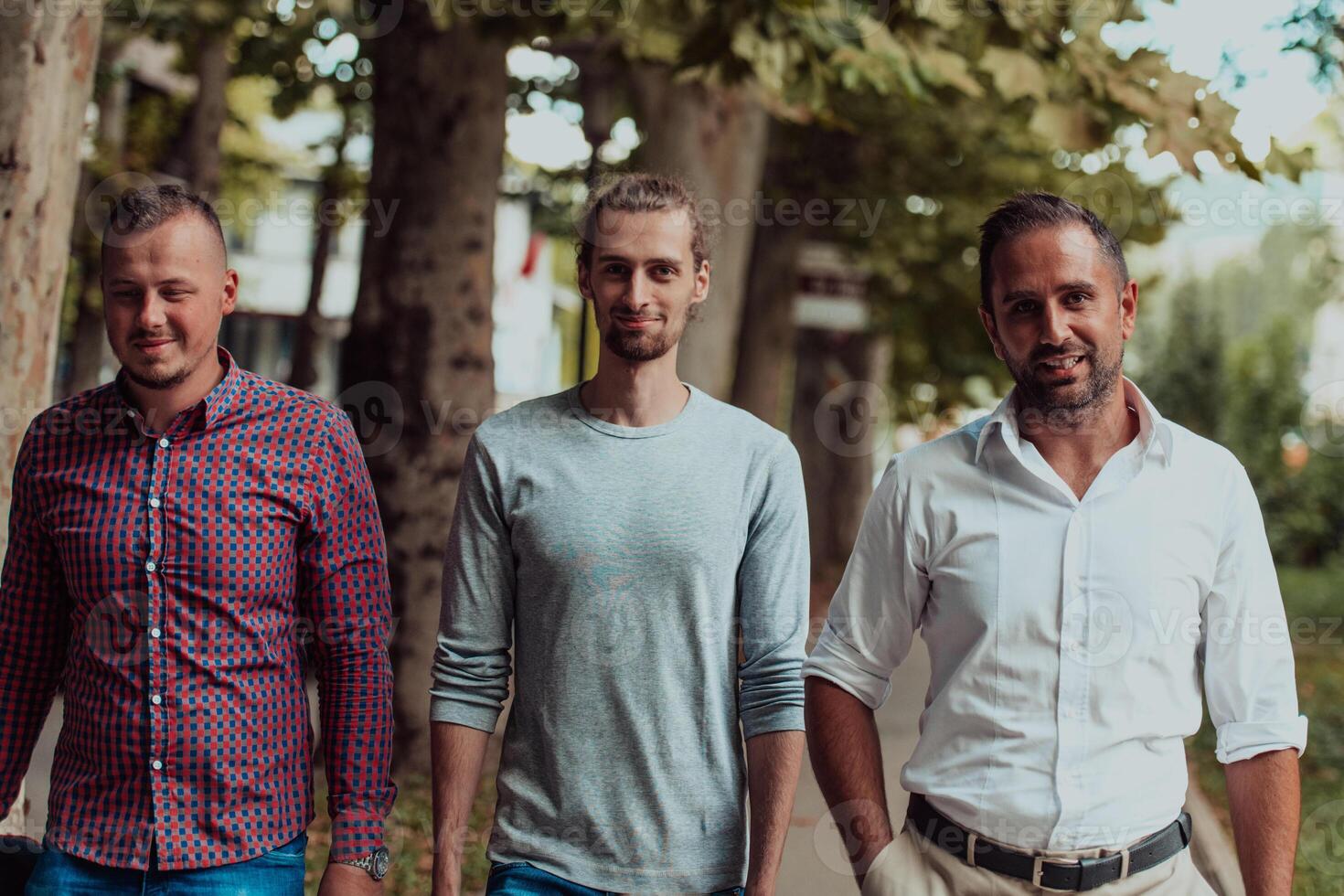 After a productive day at work, a group of diverse colleagues enjoy a leisurely stroll through a modern and natural urban setting photo