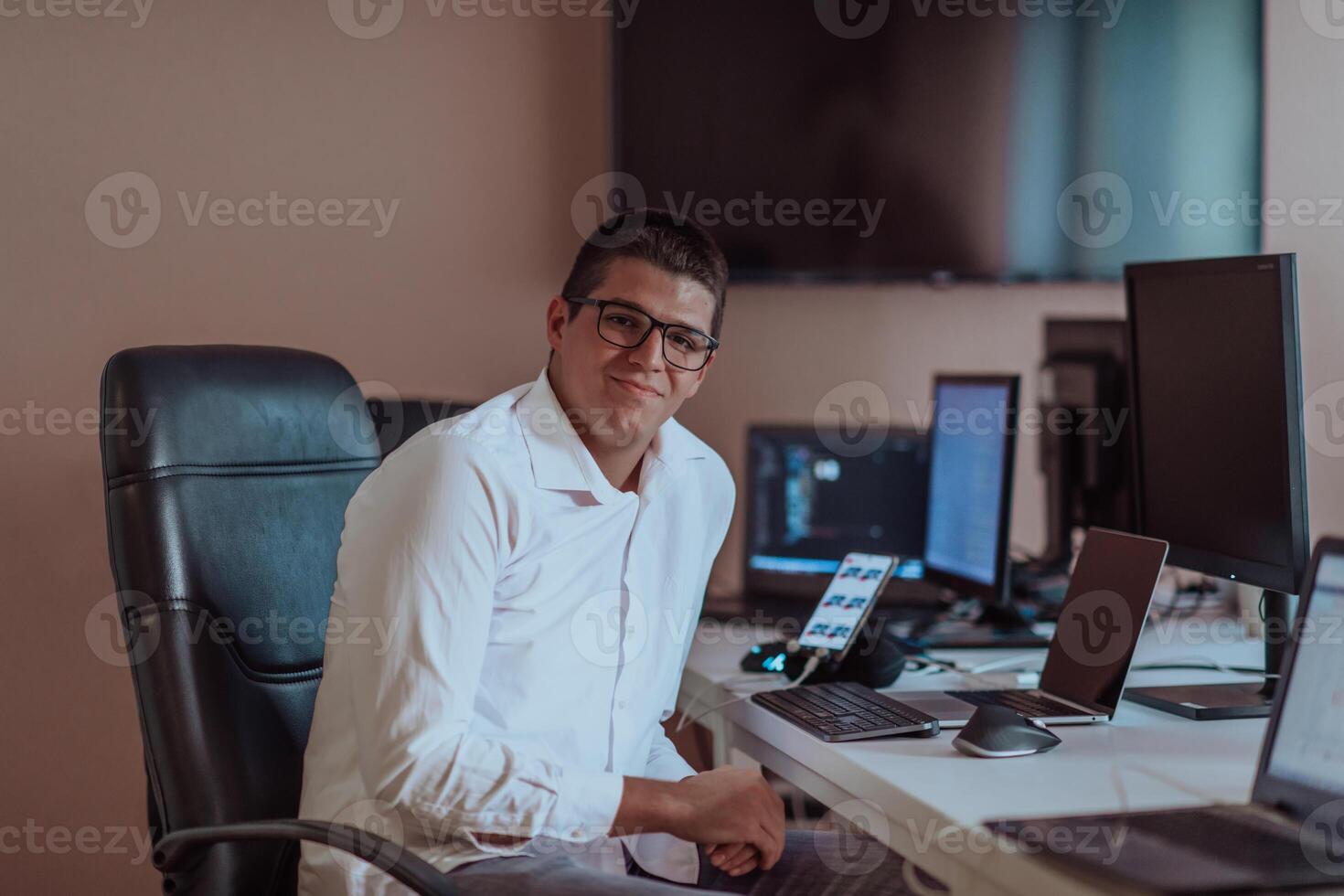 A programmer diligently testing smartphone applications while sitting in their office. photo