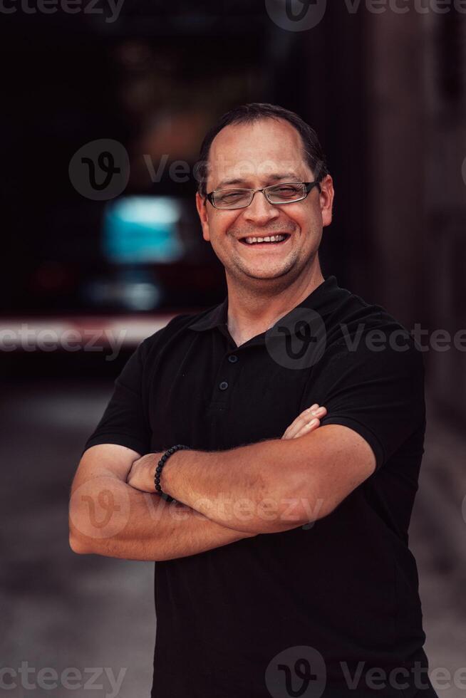 A successful businessman with crossed arms, posing outdoors photo
