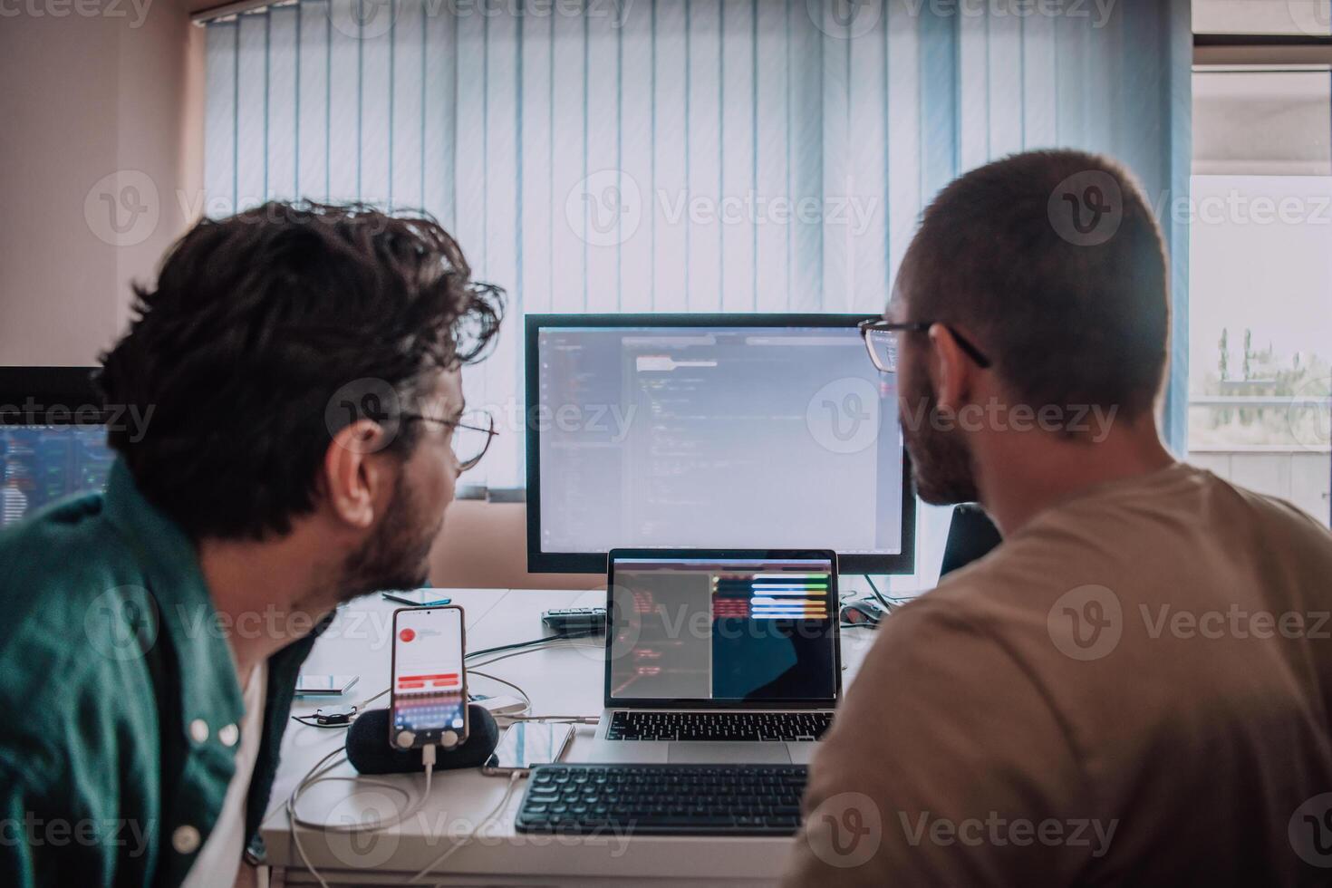 Programmers engrossed in deep collaboration, diligently working together to solve complex problems and develop innovative mobile applications with seamless functionality. photo