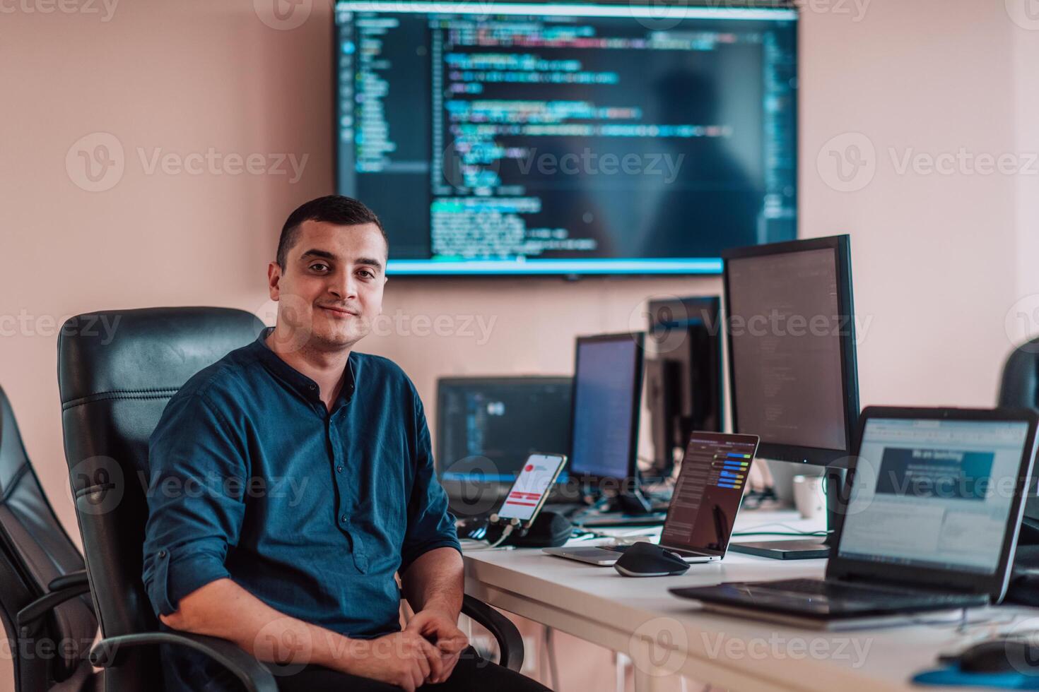 A programmer diligently testing smartphone applications while sitting in their office. photo