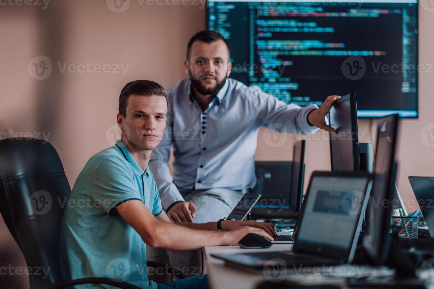 Programmers engrossed in deep collaboration, diligently working together to solve complex problems and develop innovative mobile applications with seamless functionality. photo