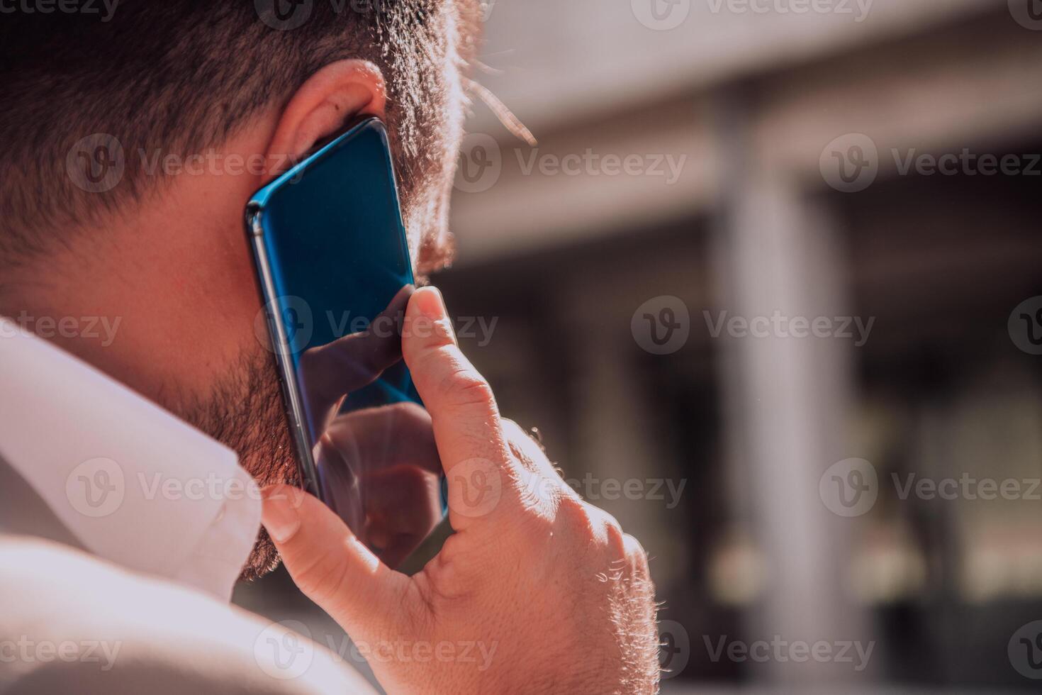 A businessman using his smartphone outdoors, showcasing the seamless integration of technology and mobility in modern professional life. photo