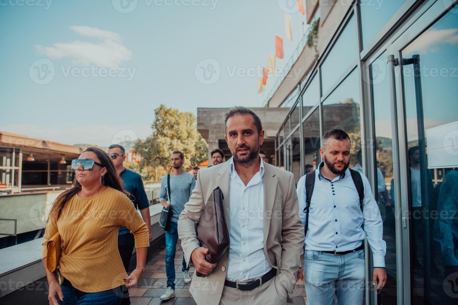 A diverse group of businessmen and colleagues walking together by their workplace, showcasing collaboration and teamwork in the company. photo