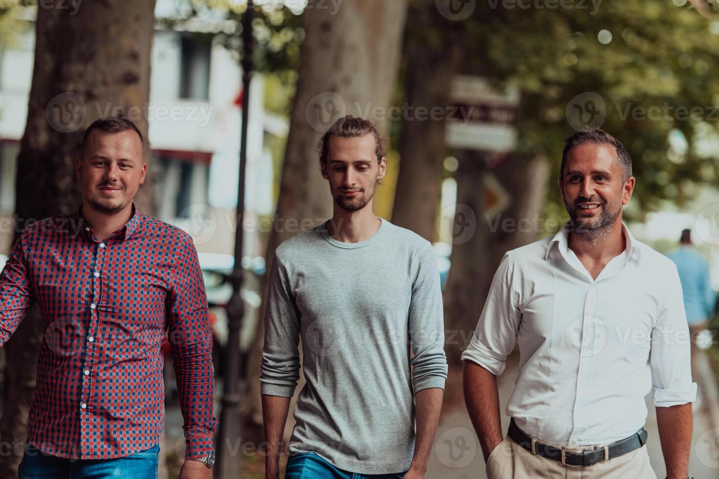 After a productive day at work, a group of diverse colleagues enjoy a leisurely stroll through a modern and natural urban setting photo