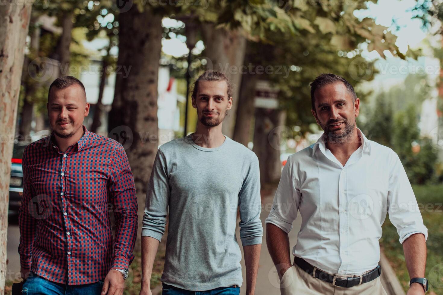 After a productive day at work, a group of diverse colleagues enjoy a leisurely stroll through a modern and natural urban setting photo