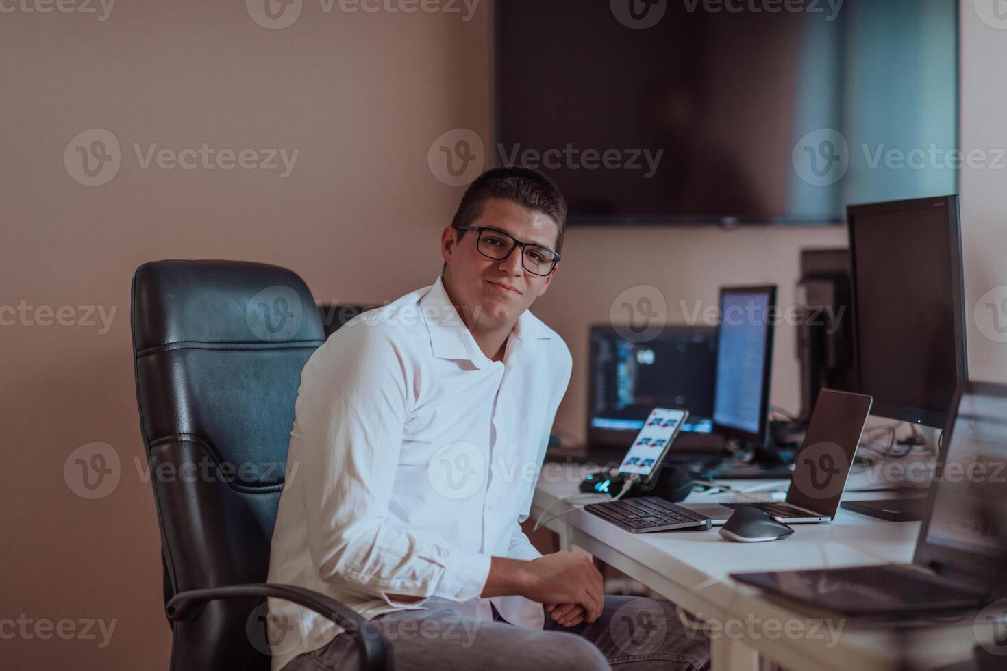 A programmer diligently testing smartphone applications while sitting in their office. photo